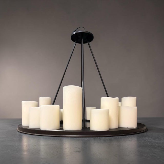 Hemel Chandelier from lighting designer Kevin Reilly. A round iron platform suspended by four-tapered rods. The platform...