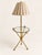 An unusual antique brass floor lamp with a circular glass shelf and custom vertically striped shade. Both sculptural and...