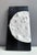 Monochrome black-and-white domino tile with tactile foam-clay lunar relief and enamel highlights on a hand-painted black...