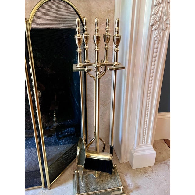 A stylish vintage eight-piece fireplace set: (1) a brass and wire four-part folding screen with brass trim, finials and...