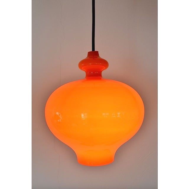 Pendant lamp by designer Hans Agne Jacobsson for Staff/AB Markaryd Glass. This pendant lamp is made of orange cased glass...