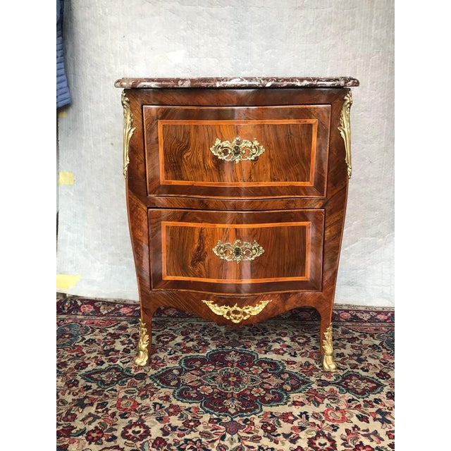This elegant louis xv style chest of drawers combines richly figured kingwood wood veneers with fine marquetry and...