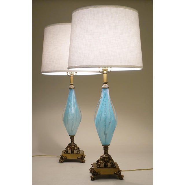 A pair of sculpturally sensual hand blown controlled thick Aqua Swirl Art Glass and ornate patine'd Brass table lamps...