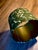 A richly patterned handmade lampshade in layered shades of emerald and forest green, featuring an exuberant botanical...