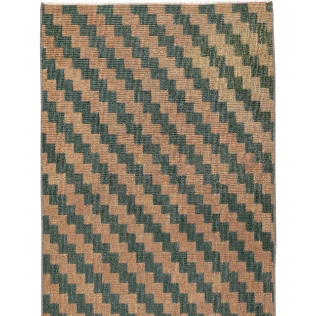 This mid-20th-century Turkish Anatolian runner presents a bold, minimalist pattern of repeating stepped diagonal bands...