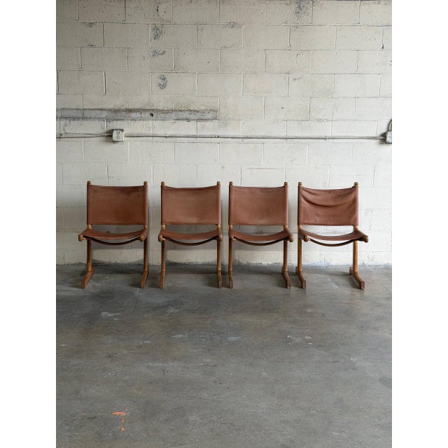 This set of four dining chairs features a minimal sling frame structure. Mid-Century Modern 1970s. Crafted with thick...