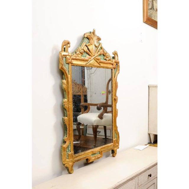 A French Louis XVI period painted and giltwood mirror from the 18th century with carved Liberal Arts Allegory symbolized...