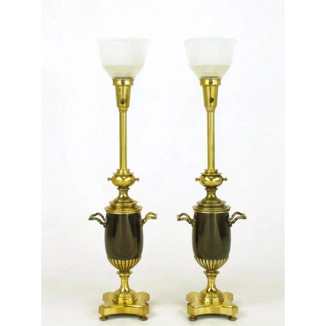 Pair of brass toned silver and bronze urn form table lamps. Urn bodies are bronze with a pair of handles. Reverse...