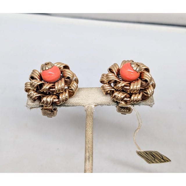 1960s goldtone curled "ribbon" edges with faux-coral bead center clip earrings. Marked "NAPIER PAT. PEND." Measure: 1 1/8...