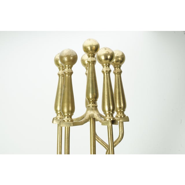 Beautiful vintage brass fireplace tool set featuring an ornate traditional design with large ball-style handles and a...