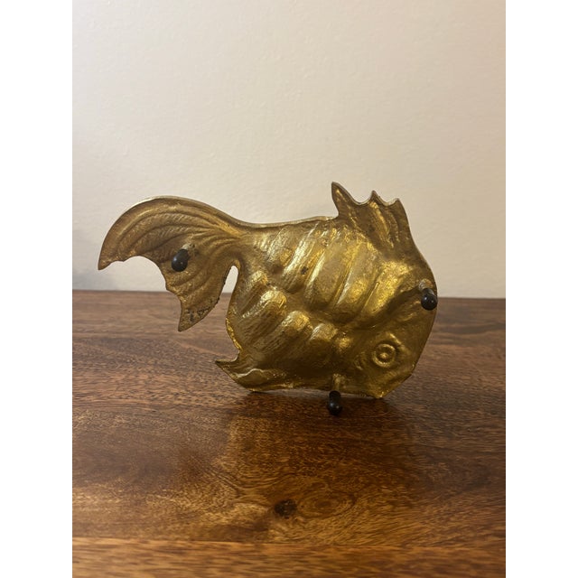 A hand-crafted solid brass fish ashtray or ring dish featuring finely hand-cut detailing and an elegant three-legged...