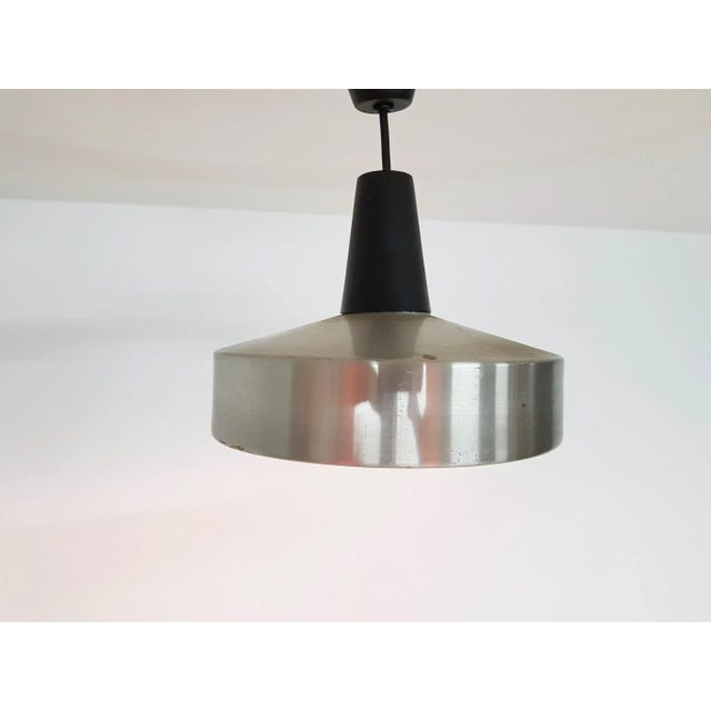 Aluminum and black pendant light This piece is attributed to the mentioned designer/maker. It has no attribution mark and...