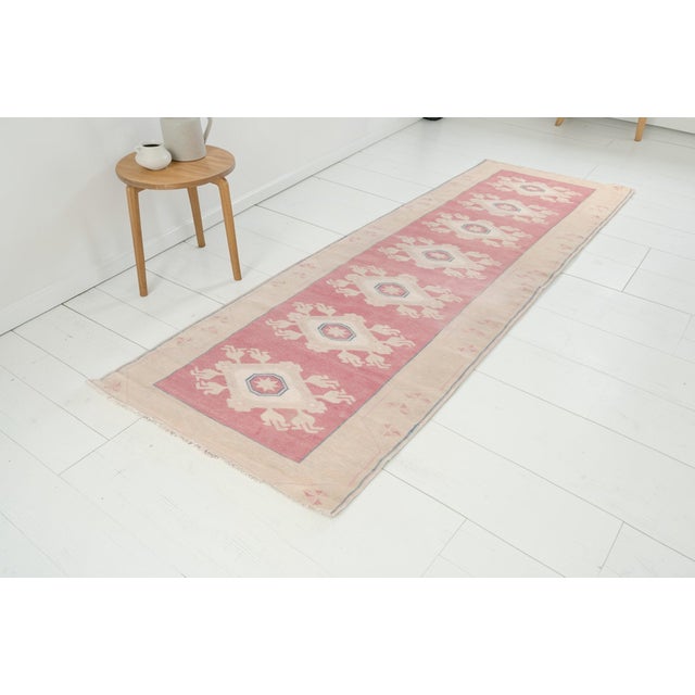 This is a vintage Turkish Oushak rug from the Mid 20th Century. The piece was hand-knotted.