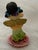 Ceramic jazz duo figurines. Man with hat and yellow jacket is playing brass trumpet. The young girl in a yellow and green...