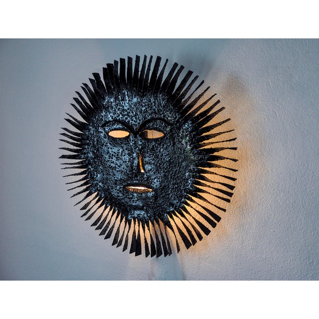 Superb and rare face wall lamp in the shape of a sun made in Spain in the 1970s. Large brutalist design which is greatly...
