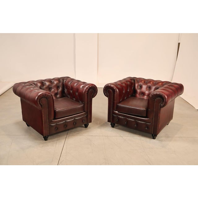 High Quality Pair of Tufted Red Leather Lounge Chairs with Brass Tack Trim, Mounted on Turned Feet