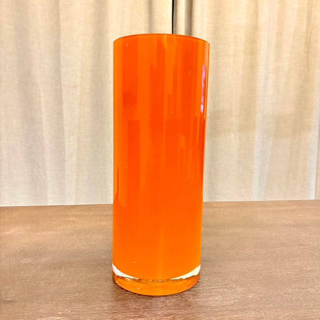 A striking vintage art glass vase in brilliant saturated orange. The tall, architectural cylinder form is beautifully...