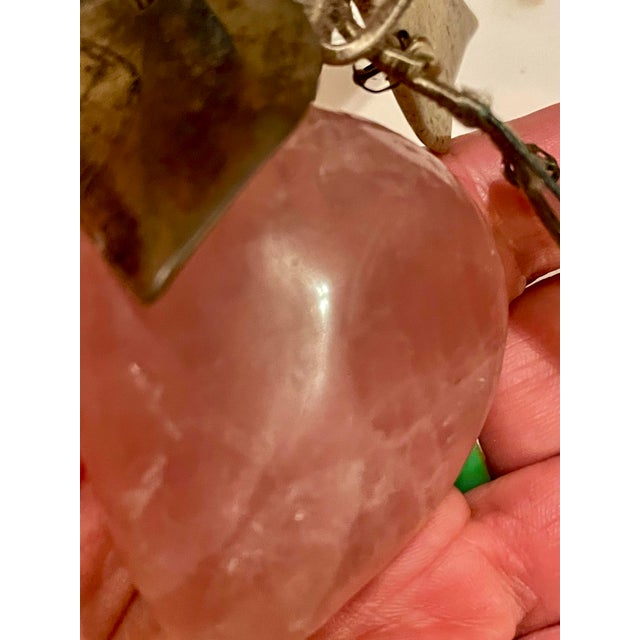 This is a lovely bright pink piece of rose quartz carved into the shape of a plum with hard stone leaves attached by satin...