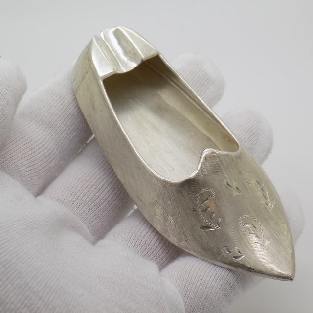 This silver ashtray is crafted in the shape of a Renaissance-style shoe, hand-chiseled in Italy during the 1950s or 1960s....