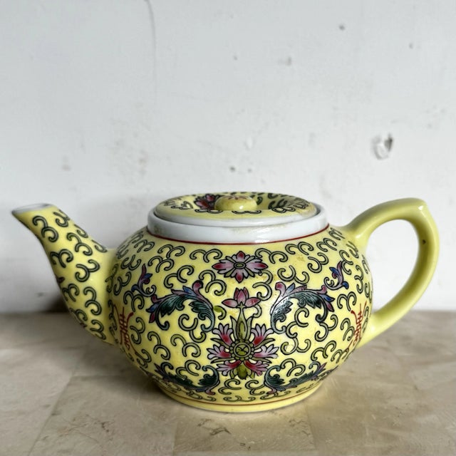 A vibrant treasure steeped in tradition, this hand-painted Famille teapot features a luminous imperial yellow glaze...