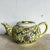 A vibrant treasure steeped in tradition, this hand-painted Famille teapot features a luminous imperial yellow glaze...