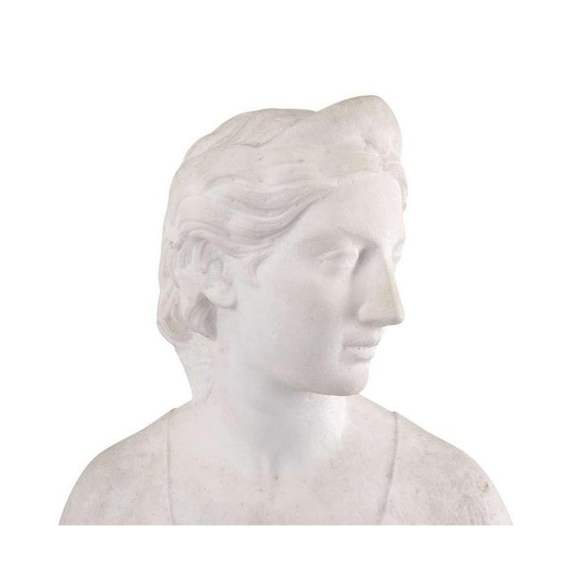 White Carrara Marble Bust of a Woman 1860s - Attributed to Hiram Powers This refined marble bust depicts a young woman...