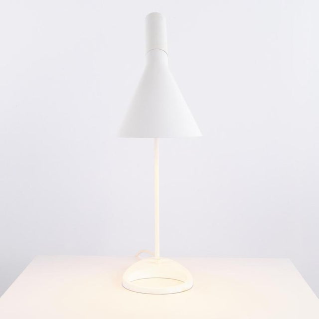 Aj table lamp designed by arne jacobsen in 1957 for louis poulsen. The lamp is made in white lacquered metal with a...