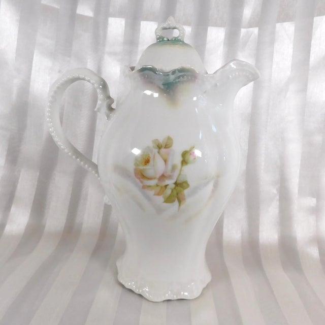 This is a Leuchtenberg white floral chocolate pot with a matching lid. The chocolate pot has a white rose design with...