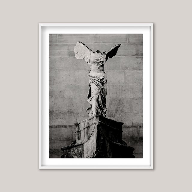 A black and white study, lithographic in style, of The Winged Victory of Samothrace, a rare Greek sculpture whose original...