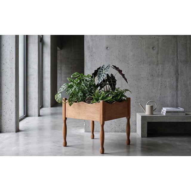 Solid oak planter stand attributed to Danish designer Henning Kjærnulf, produced in Denmark during the 1960s. The piece...