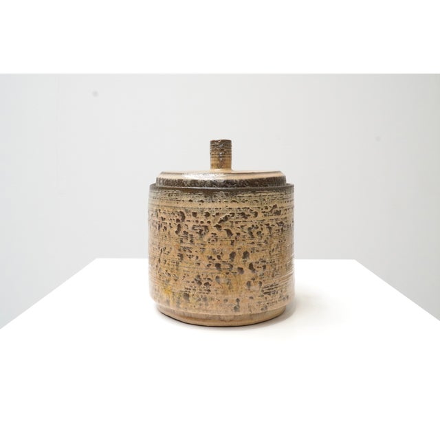A ceramic lidded pot by Belgian ceramist Roger Vandeweghe for Amphora. The pot has a cylindrical form with a uniform,...