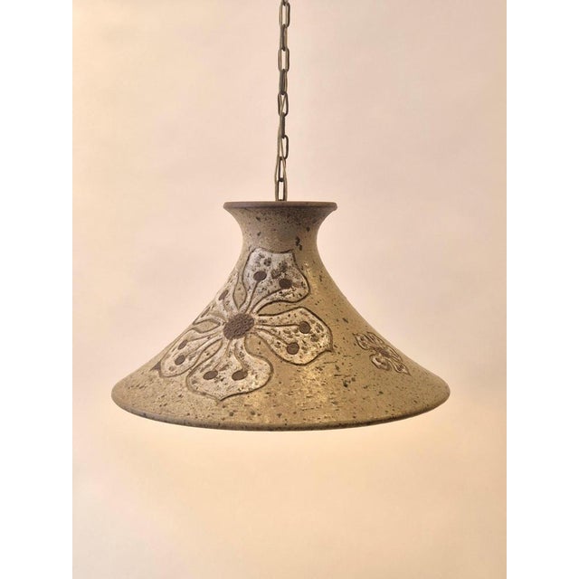 A rare stoneware pendant by danish ceramist Mette Lokke Stiil, 1960/70s. Glazed decor of flowers. Height excluding chain...