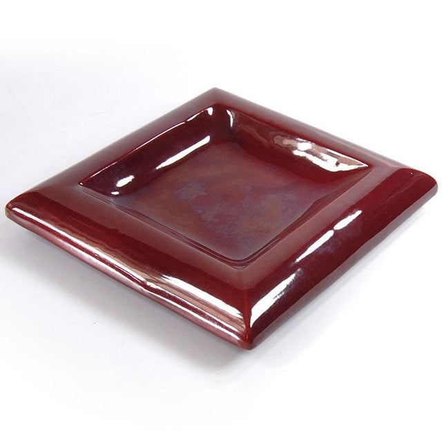 This decorative ceramic plate features a deep burgundy glaze. It comes from the Italian manufacturer Italika Ars, dating...