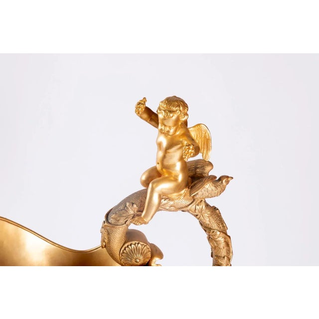 After Clodion. Pair of bronze ewers with two patinas representing bacchanalia scenes after Clodion. Circular base with...