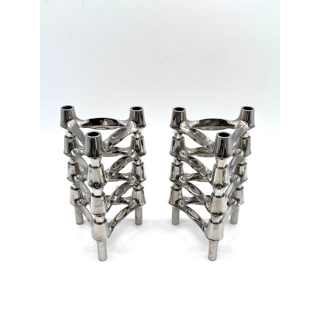 Set of eight modular candle holders made of chrome-plated metal. The elements are stackable and combinable, allowing for...