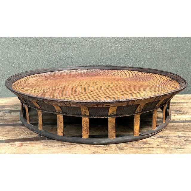 Elevate your interior with this monumental vintage pedestal tray, a masterclass in artisanal weaving and organic design....