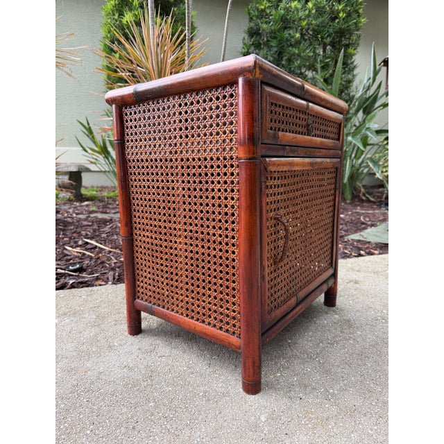 A charming vintage burnt bamboo and cane accent cabinet with a warm, inviting patina and plenty of texture. Features a...