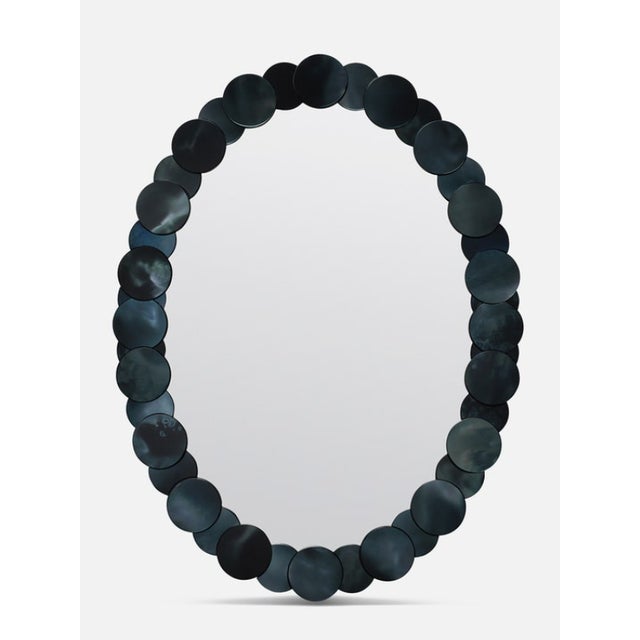 The oval-shaped Saffi, featuring a frame of overlapping antiqued mirror disks, is the perfect choice for any high-traffic...