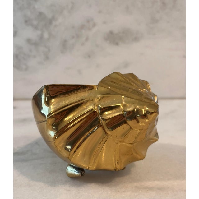 Vintage Hollywood Regency brass conch seashell with small seashell "feet". Heavy and perfect for paperweight or decorative...
