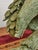 A distinctive stylized statue of an eagle with outstretched wings, masterfully carved from a solid block of green...