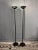 Large pair of floor lamps in black lacquered metal. The diffuser is composed of a large glass disc and a perforated metal...
