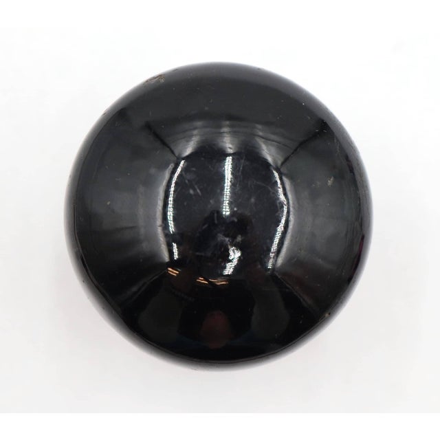 Antique dummy door knob set with a black porcelain ceramic knob paired with a brass rosette. The original mounting screws...
