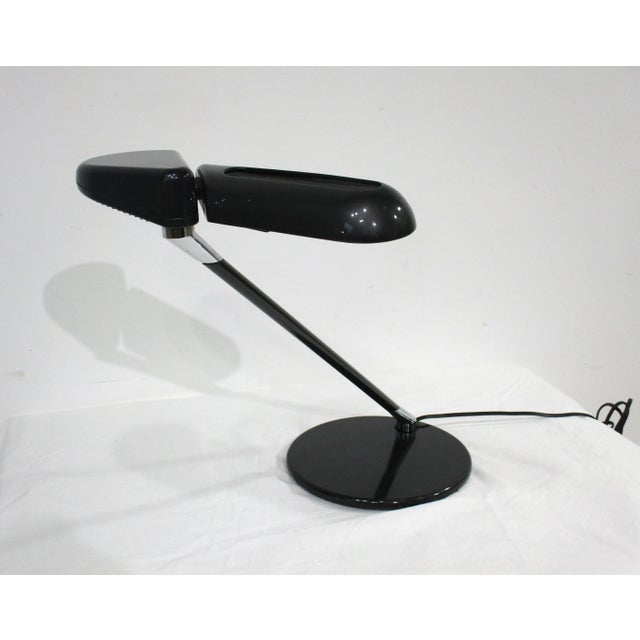 A dark gray Mid Century industrial styled metal desk lamp with heavy base , chrome accents , black mesh screen over the...