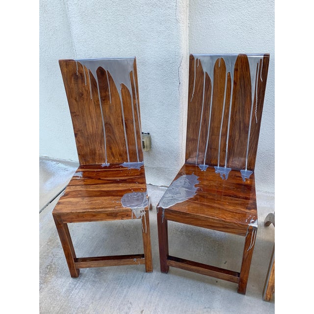 A set of 4 dining or side chairs in hand built from the hard Acacia wood species and decorated in dripped steel metal by a...