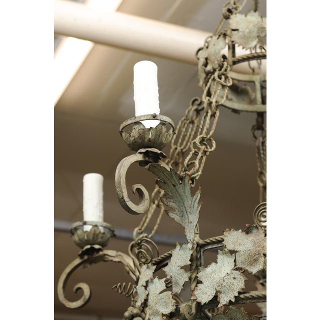 This is an extremely unique two-tier French wrought iron chandelier with an intricate vine and tendril design throughout...