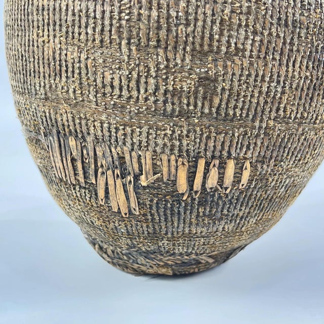This Ethiopian basket container with lid is a finely handwoven example of traditional functional craft, created using...
