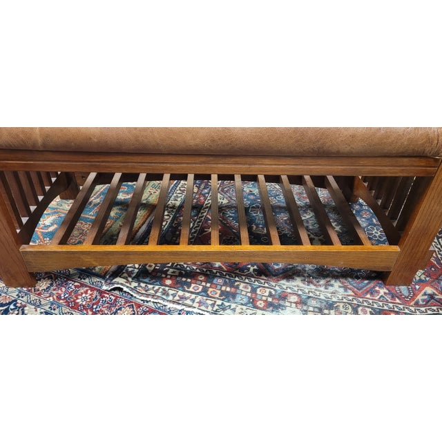 Fine arts and crafts mission bomber leather bench. Features solid oak frame with a tan leather seat. Measuring 44 inches...