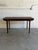 This minimalist dining table features a rectangular top that pulls apart to accommodate two integrated draw-out extension...