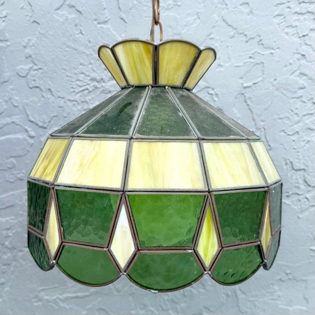 Charming vintage Mid-Century Modern stained glass pendant light featuring a geometric shade in layered shades of green,...