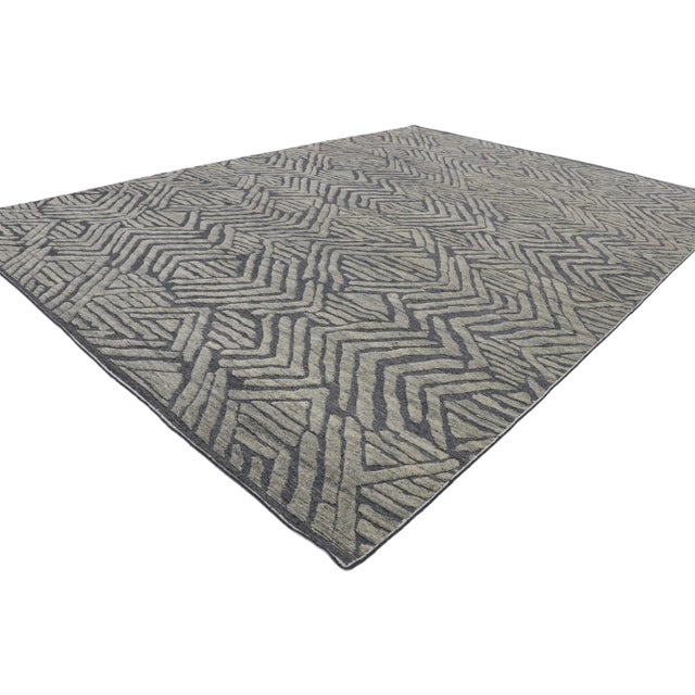 This hand knotted wool modern high-low gray area rug features a geometric pattern composed of stacked horizontal bands...